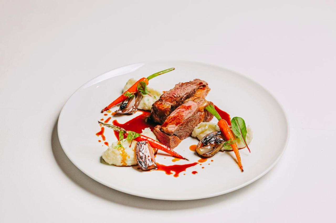 Ap Lago Montargil - Conference & Spa Εξωτερικό φωτογραφία The photo features a beautifully plated dish. At the center, there are slices of a tender meat, likely beef, showcasing a juicy pink interior. Accompanying the meat are several elements: vibrant orange carrots, perhaps roasted or glazed, and dollops 